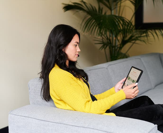 Een mevrouw met een tablet op de bank