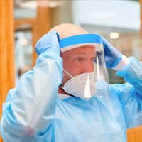 een zorgprofessional met beschermende kleding aan