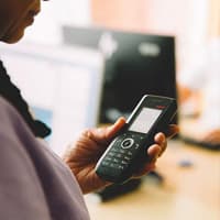 een zorgverlener met een telefoon in haar handen