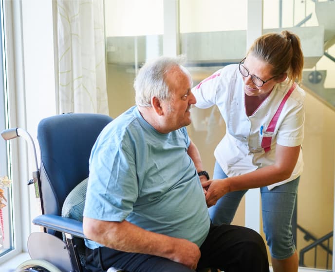 een zorgprofessional die een patient helpt